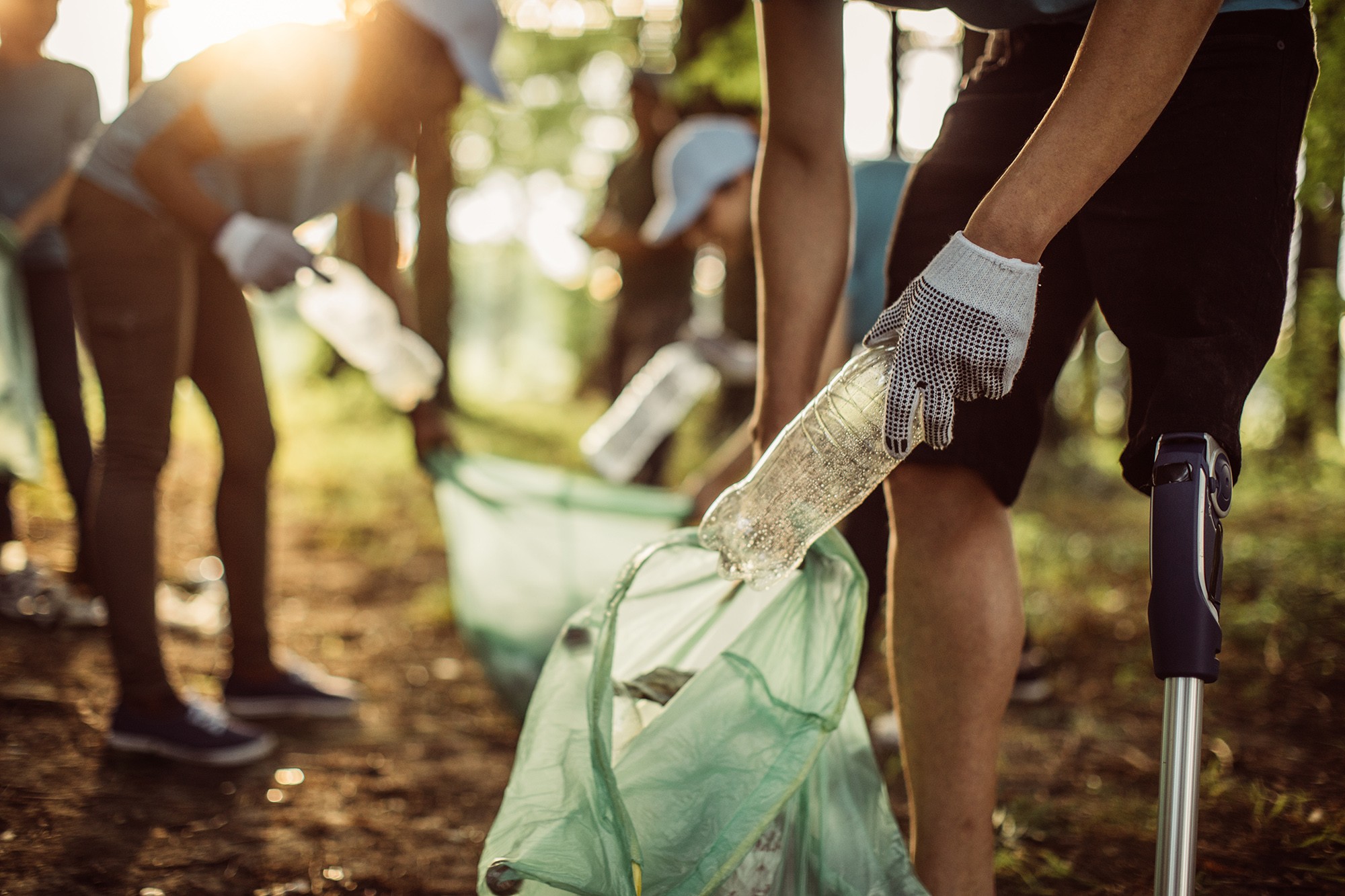 Charity workers collecting littered plastic bottles
